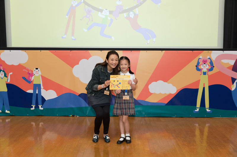 平機會委員梁頌恩女士頒發獎狀予高小組入圍者何慧琳小朋友。